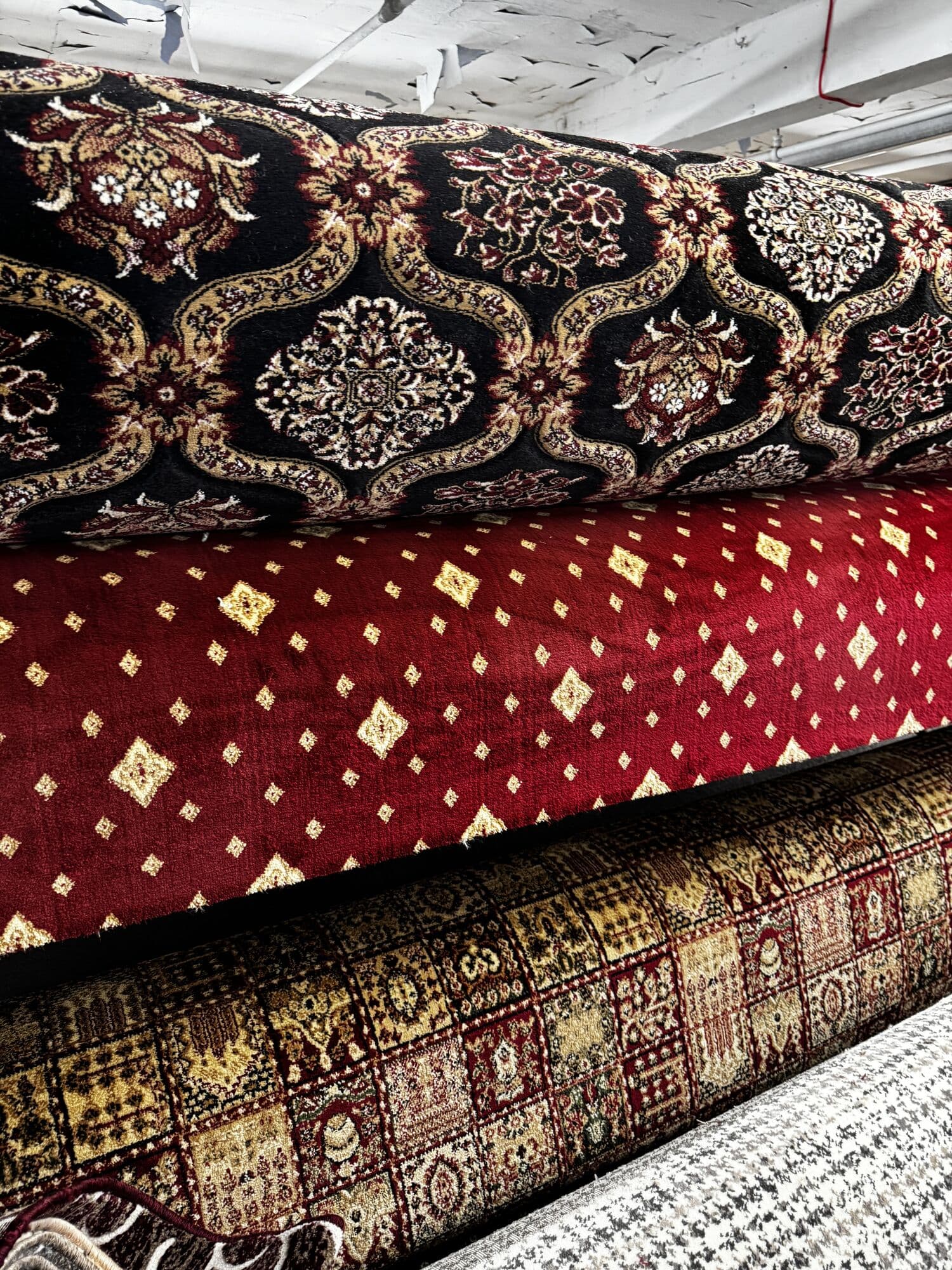 Traditional red, black and gold patterned carpet rolls